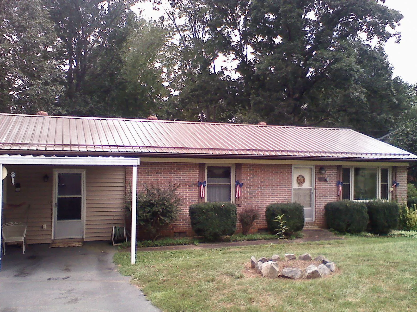Bronze metal roof and carport on a brick ranch home — Roof Repair work by our crew in Providence